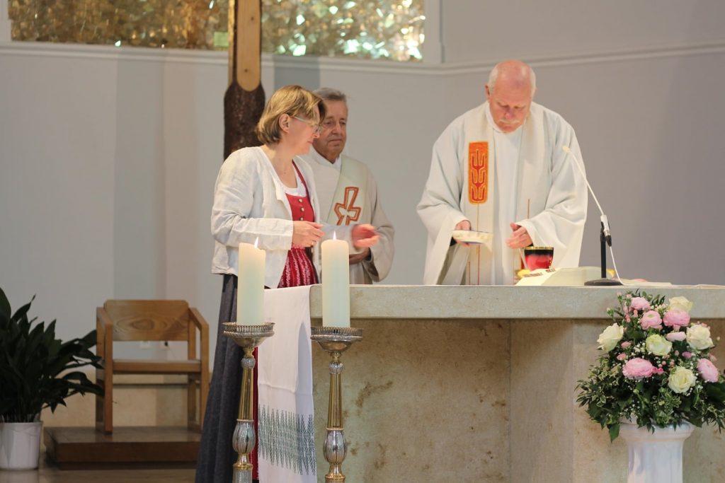 Kommunionsspenderin mit Diakon und Pfarrer am Altar. © Nico Trimmel