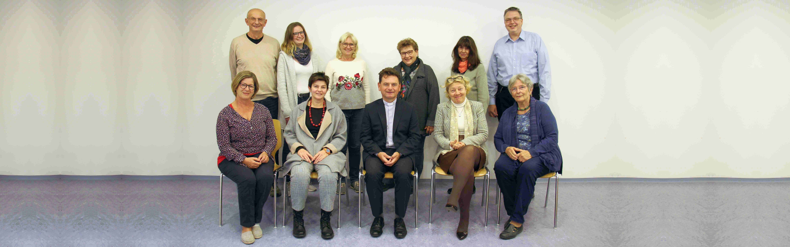 Zwölf Personen stehend und sitzend in einem Gruppenfoto. Pfarrgemeinderat 2021. © Nico Trimmel